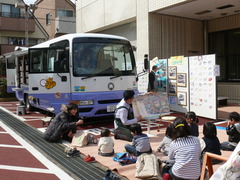 ひまわり号の前で、バスの絵本を読んでいます