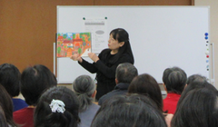 講師の市川雅子さんが手に絵本をもって紹介しているところ